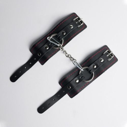 Черные кожаные наручники с красной строчкой