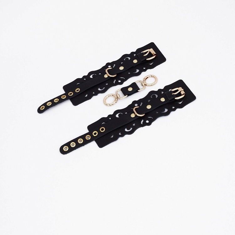 Черные кожаные наручники с узорами и золотистой фурнитурой