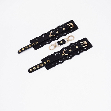 Черные кожаные наручники с узорами и золотистой фурнитурой